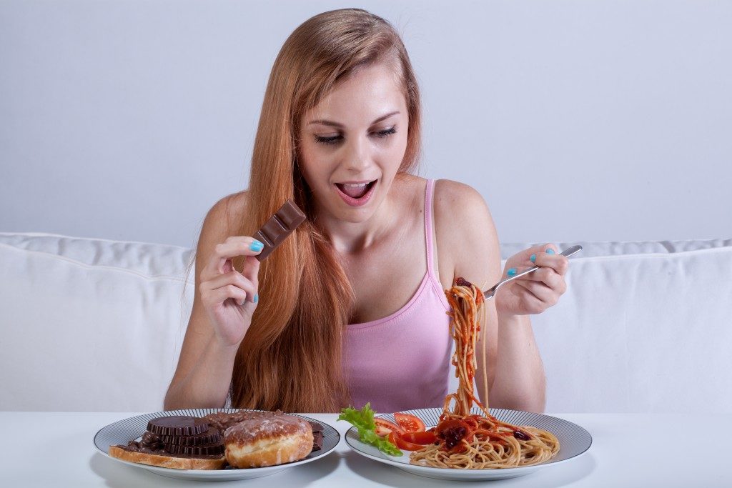 Girl suffering from bulimia eats dinner with dessert