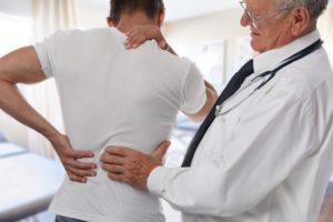 doctor examining a man with back pain