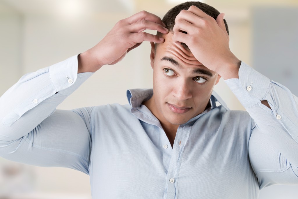 Man feeling his hair