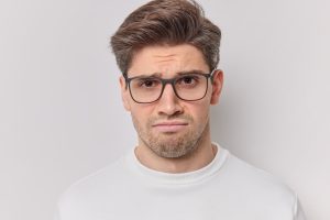 A man not happy while wearing eyeglasses