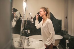 Young woman cleaning teeth in bathroom