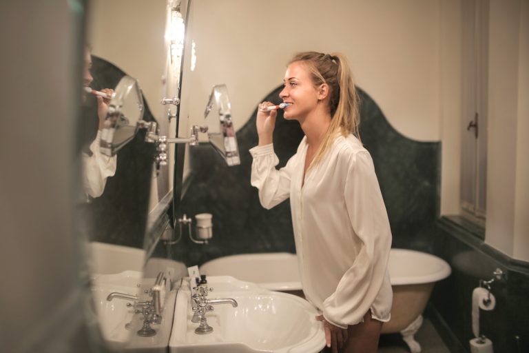 Young woman cleaning teeth in bathroom