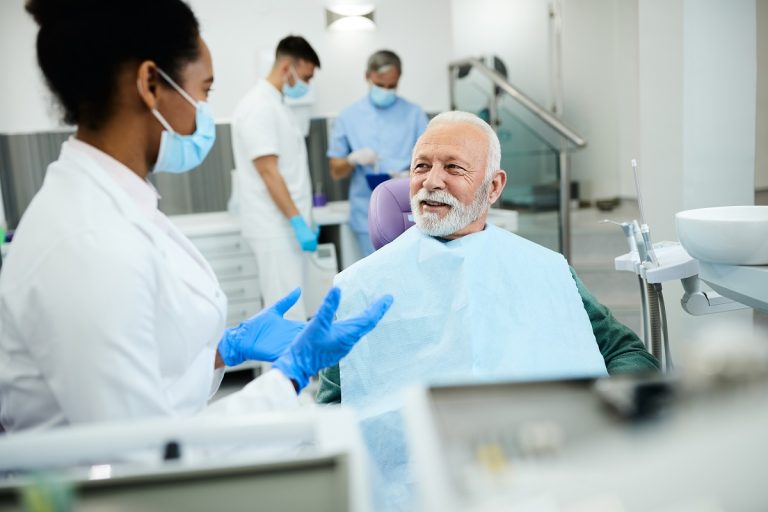 elderly man talking to female dentist