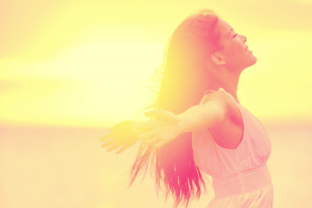 woman in white dress embracing the golden sunshine