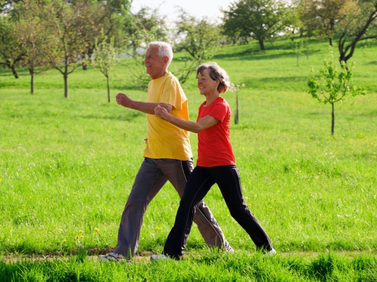 Senior couple exercising at a park.